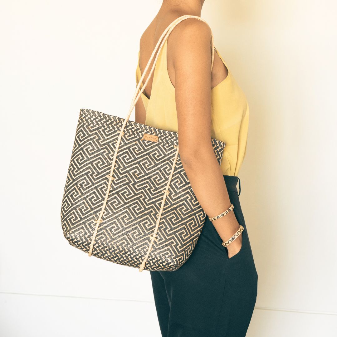 A woman wearing handmade rattan straw shoulder bag suitable for summer boho chic style with black and white colour and ethnic pattern