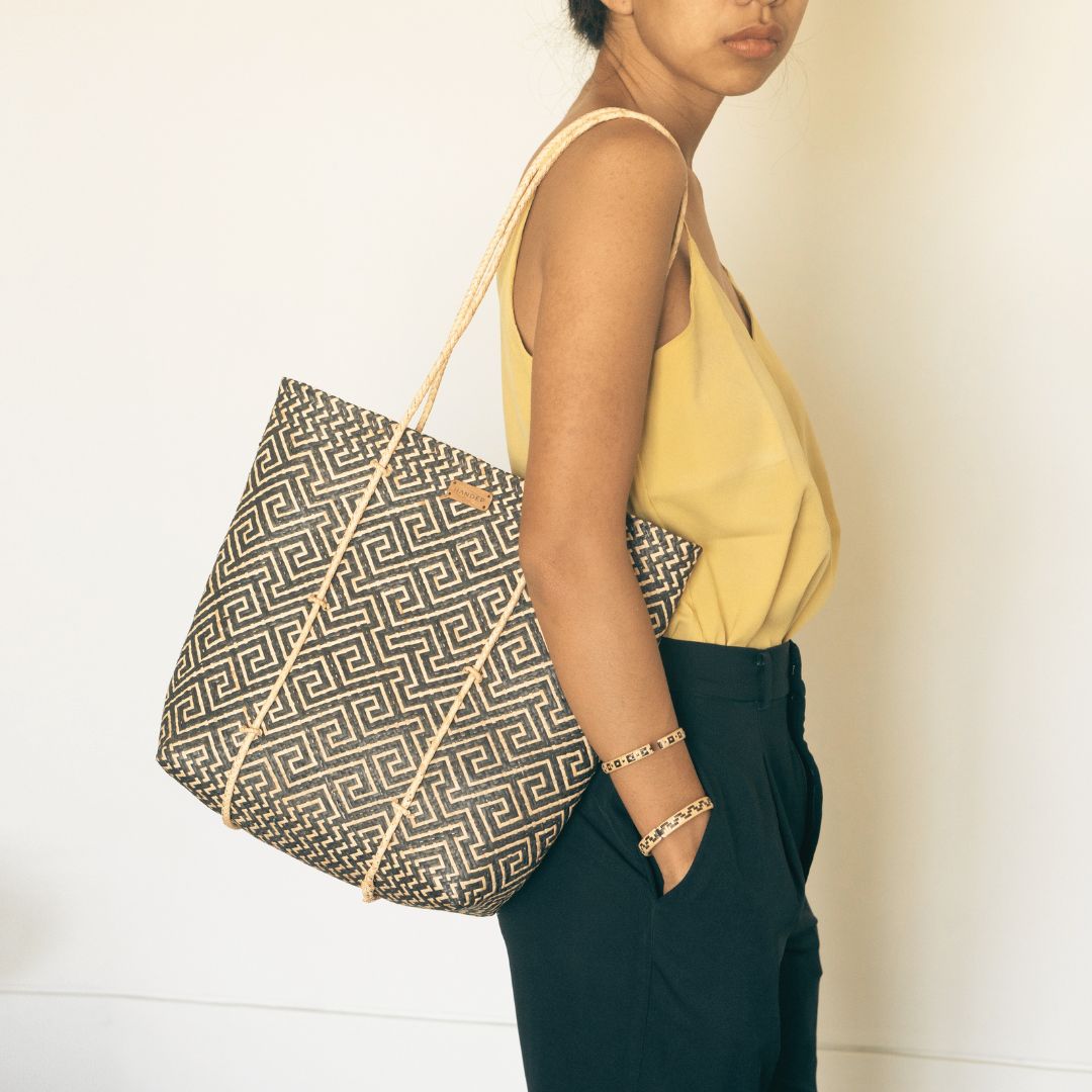 A woman wearing handmade rattan straw shoulder bag suitable for summer boho chic style with black and white colour and ethnic pattern