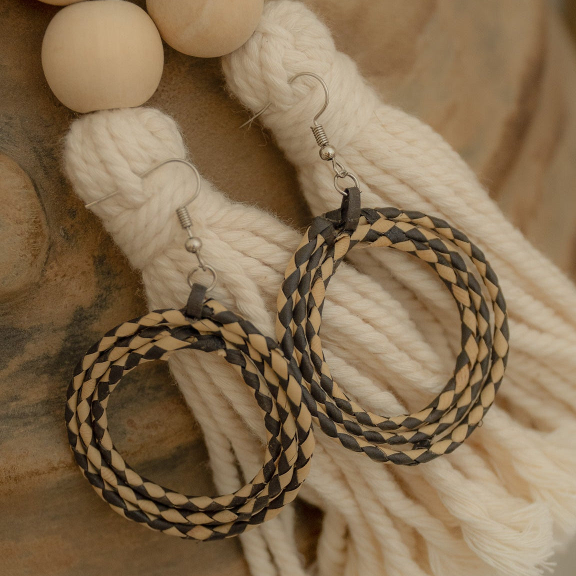 Handwoven rattan earrings in black and beige, showcasing artisanal craftsmanship and eco-friendly style.