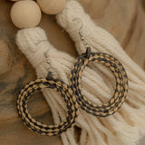 Handwoven rattan earrings in black and beige, showcasing artisanal craftsmanship and eco-friendly style.