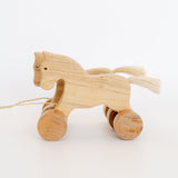 Handmade Wooden Pull-Along Horse Toy with a natural pine wood body, teak wood wheels, and a pull-along string, designed for kids aged 3+