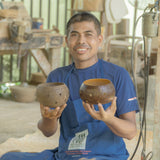 Handcrafted coconut shell tea light holder with star-shaped cutouts and a gold-painted interior, sustainably made in Bali from leftover coconut shells