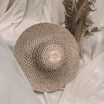 Kate Handwoven Rattan Sunbrim Hat in a stylish mix of natural and black colours. The wide-brimmed hat features intricate handwoven rattan patterns with a natural beige tone contrasted by black accents along the brim and crown. Lightweight and breathable, this artisanal sun hat offers both sun protection and a chic, eco-friendly boho fashion statement.